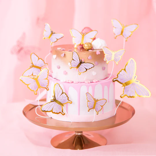 10 tårtdekorationer med form av små pappersfjärilar i lila och guld, dekorerad på tårta till dop, babyshower och fest