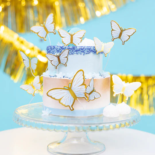 10 tårtdekorationer med form av små pappersfjärilar i ljusblått och guld, dekorerad på tårta till dop, babyshower och fest