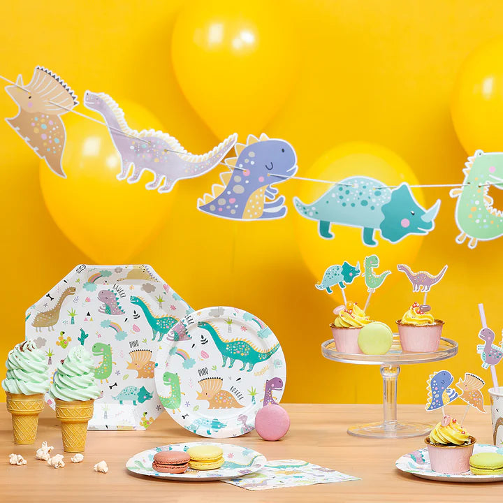 Dinosuarie inspirerande kalasdukning med engångstallrikar, cake toppers och girlang till dinosauriekalas och barnkalas