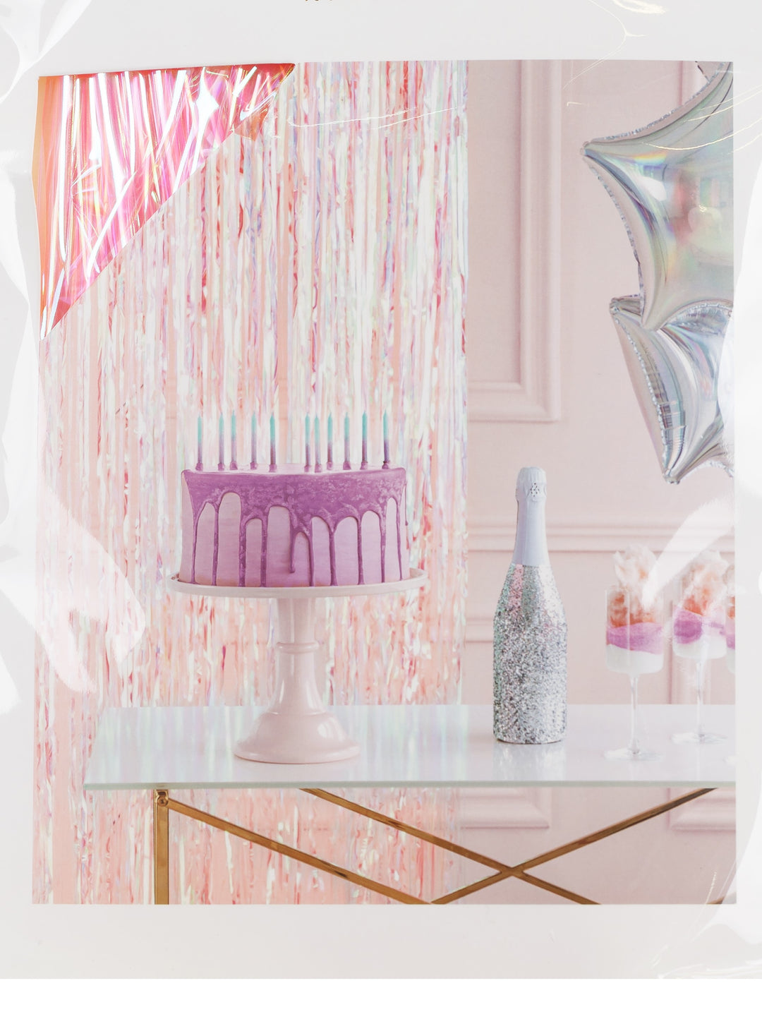 Rosafärgat glitterdraperi dekorerat bakom ett kalasbord med tårta, glas och ballonger