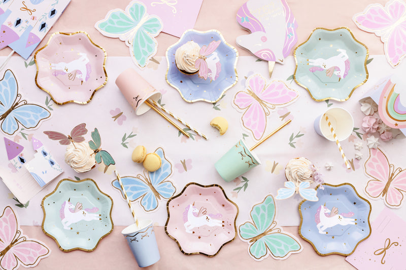Inspirerande kalasdukning med engångstallrikar, muggar och servetter med fjärilar och unicorn-tema i pastellfärger för barnkalas och fest