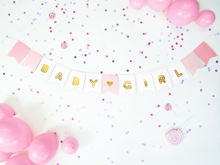 Girlang med vimplar i rosa nyanser och texten Baby Girl dekorerad med ballonger och konfetti för baby shower och kalas