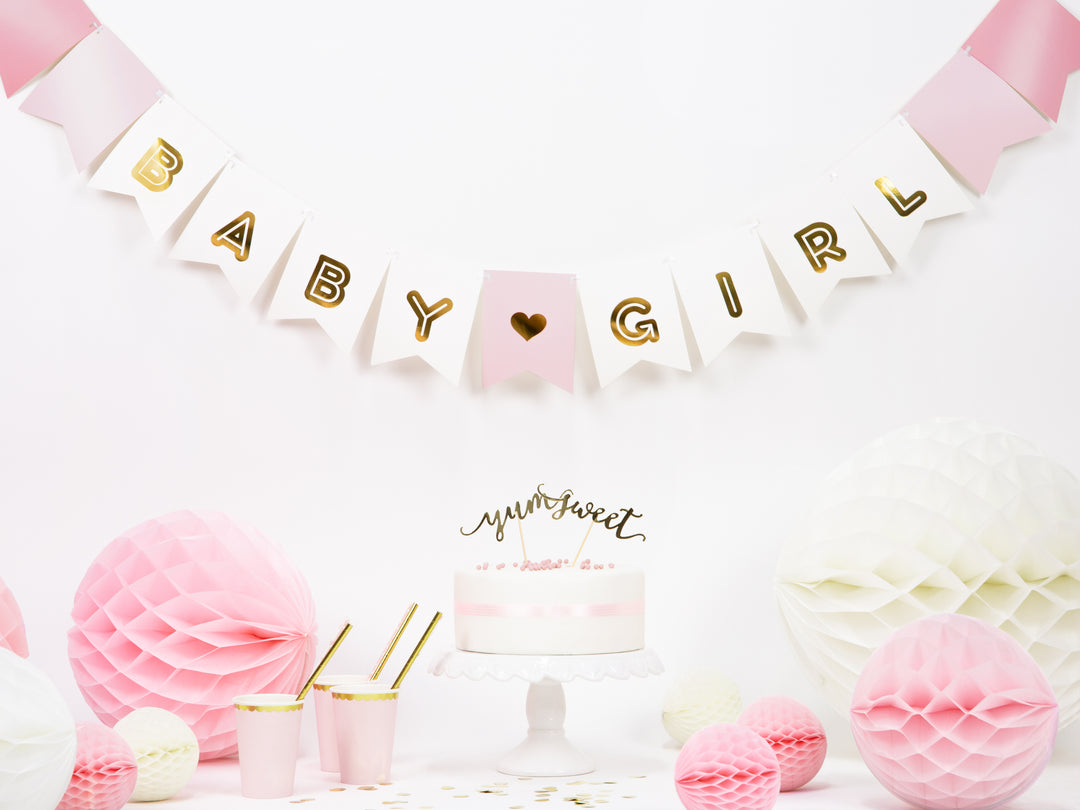 Girlang i rosa nyanser med vimplar och texten Baby Girl i guld dekorerad vid kalasbord för baby shower och fest