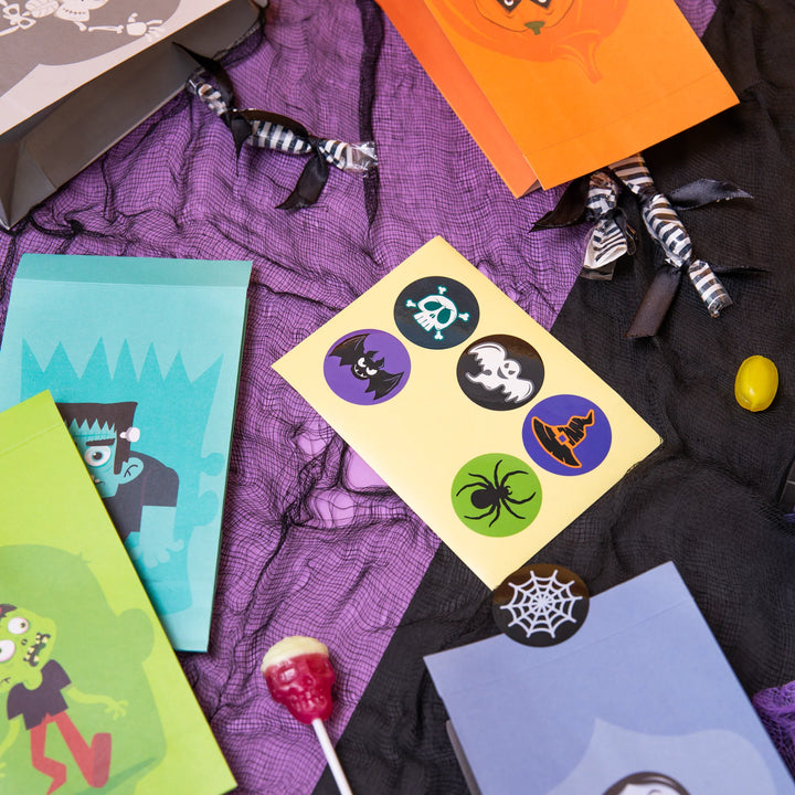 Halloween Monster kalaspåsar med klistermärken. Godispåsar med monster-motiv dekorerat för fiskdamm, Halloween-kalas och barnkalas
