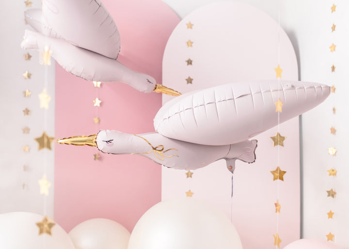 Rosa stork folieballonger med stjärngirlanger i guld dekorerat till dop, babyshower och barnkalas
