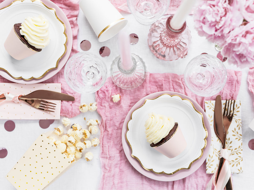 Inspirerande festdukning med engångstallrikar, muggar och servetter i  vitt, guld och rosa för fest och kalas